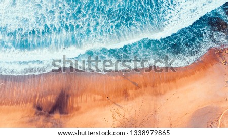 Luftaufnahme Panoramadrohne Blick auf den blauen Ozean Wellen, die am Sandstrand in Portugal erdrücken.