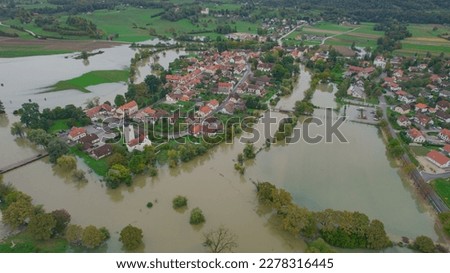 AERIAL: Autumn flooding around rural village with large areas of muddy floodwater. River floods came dangerously close to residential buildings in countryside after abundant rainfall in fall season.