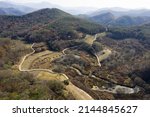 Aerial and autumnal view of dirt trail and trees at Dolline Wetland at Gulbongsan Mountain of Ugok-ri near Mungyeong-si, South Korea 
