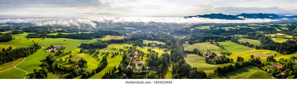 Aerial Bad Toelz Bavarian Alps. Golf Course. Blomberg Mountain. Morning Drone Shot With Some Clouds In The Sky