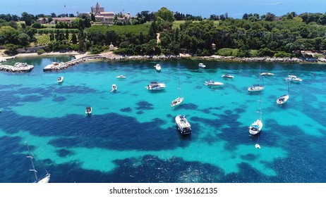 Aerial bird view of Ile Saint Honorat about half mile off shore from French Riviera town of Cannes showing large number of boats moor in shallow and protected Plateau du Milieu between the islands