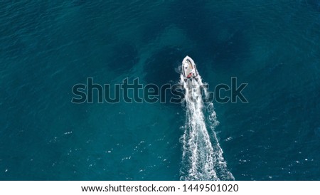 Aerial bird's eye view of inflatable rib boat cruising in high speed in turquoise clear water sea