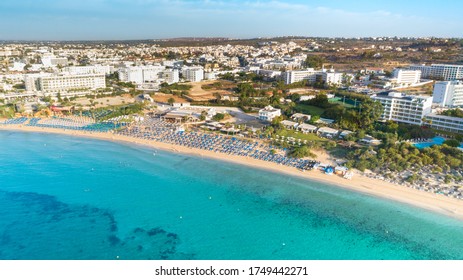 Aerial Bird's Eye View Of Pantachou - Limanaki Beach (Kaliva), Ayia Napa, Famagusta, Cyprus. The Landmark Tourist Attraction Bay With Golden Sand, Sunbeds,sea Bar Restaurants In Agia Napa From Above.