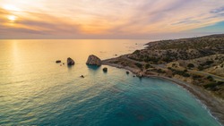 Aerial Bird's Eye View Of Petra Tou Romiou, Aka Aphrodite's Rock A Famous Tourist Travel Destination Landmark In Paphos, Cyprus. The Sea Bay Of Goddess Afroditi Birthplace At Sunset From Above.