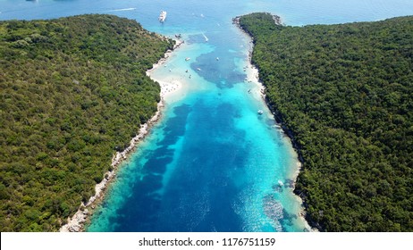 Aerial bird's eye view photo taken by drone of tropical exotic seascape and sandy beach with turquoise clear waters and pine trees