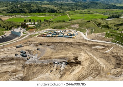 Aerial Chiquita Canyon landfill dump site, trucks dumping trash and bulldozer compacting trash and dirt. Gas collection systems to capture methane gas - Powered by Shutterstock