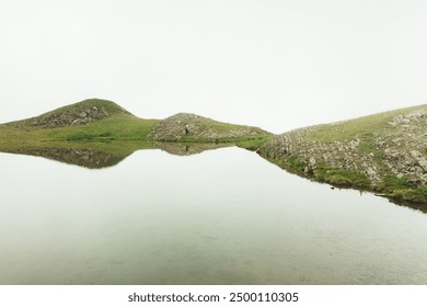 Aerial cinematic view hiker trekking in Georgia visit special alpine Sakori lake high in caucasus mountains in Georgia. Misty lake outdoors explore caucasus - Powered by Shutterstock