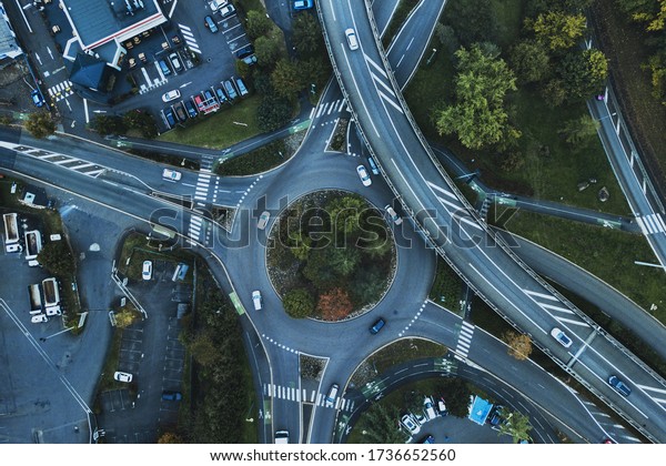 Aerial city\
landscape with motorway in urban metropolis, bird\'s eye view.  Cars\
moving at street on modern  expressway. Interchange road highway,\
rondabout junctions\
freeway.
