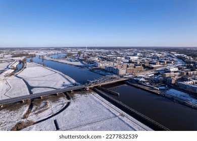 Aerial cityscape after snowstorm and steel draw bridge over river IJssel   white floodplains Dutch Hanseatic medieval tower town Zutphen  The Netherlands  Climate   weather condition concept