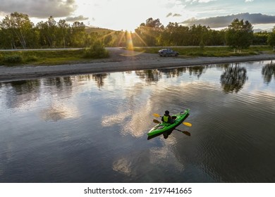 Aerial close up photo of girl paddling in green kayak, sunset, mountain lake in Scandinavian mountains. Slow motion, Norway, Sweden - Powered by Shutterstock
