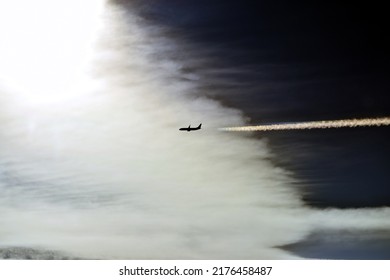 Aerial close up view of a commercial passenger aircraft cruising over Europe photographed during a flight from another aircraft with a natural color contrast and a rainbow contrail