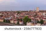 Aerial day to night transition timelapse panorama over Brussels skyline in Schaerbeek near railway station. Residential blocks, Saint-Servais Church and Town Hall surrounded by red rooftops in Belgium