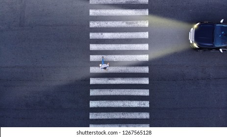 Aerial. Driving In Low Light Conditions. Pedestrian Crossing And One Car With Headlight. Night Transportation Top View. 