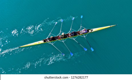 Aerial drone bird's eye view of sport canoe operated by team of young women in turquoise clear waters - Powered by Shutterstock