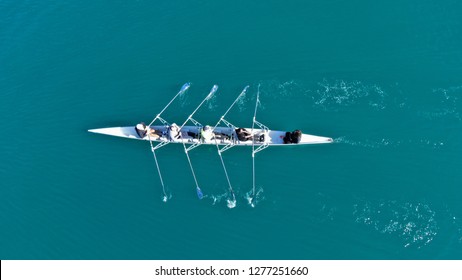 Aerial drone bird's eye view of sport canoe operated by team of young women in emerald clear sea - Shutterstock ID 1277251660