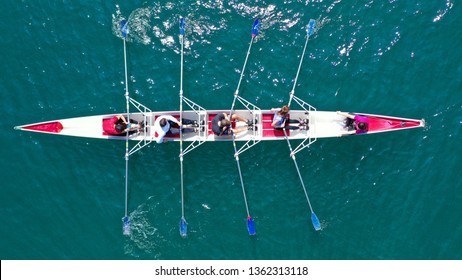 Aerial drone bird's eye view photo of red sport canoe operated by team of young men and women in emerald clear sea - Shutterstock ID 1362313118