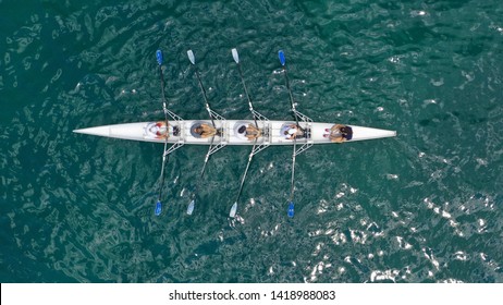 Aerial drone bird's eye view of sport canoe operated by team of young women in deep blue sea waters - Shutterstock ID 1418988083