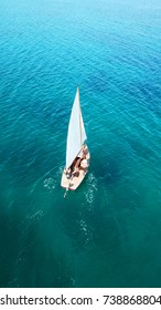 Aerial Drone, Bird's Eye View Of Sail Boat Cruising Near Tropical Island With Turquoise And Sapphire Sea