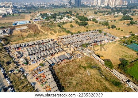 aerial drone decending shot of banjara market in gurgaon delhi showing disorganized temporary tents houses in slums showing this famous handicraft and furniture market surrounded by cars