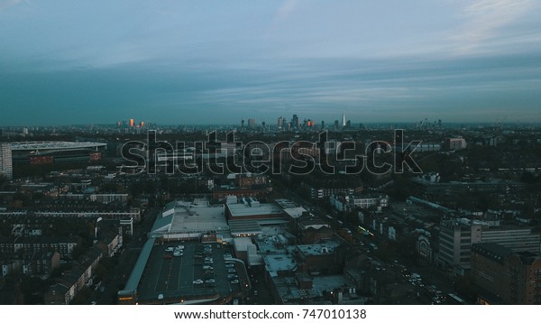 Aerial drone flight over\
London England, UK.  Emirates stadium in mid-ground. London\
skyline.