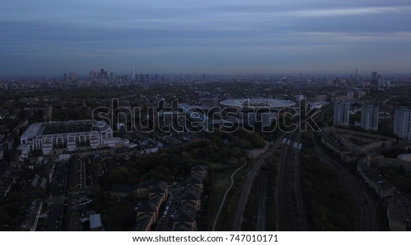Aerial drone flight over\
London England, UK.  Emirates stadium in mid-ground. London\
skyline.