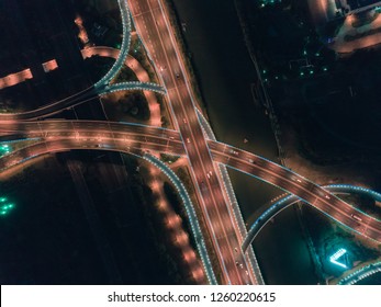 Aerial drone flight over nightroad traffic. Two-level road junction. Top view.