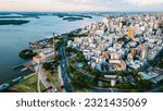 Aerial Drone Fly Above Beautiful Cityscape of Porto Alegre Brazil Neighborhood Gasometro, Guaiba Lake, Architecture and Road Traffic with Warm Skyline