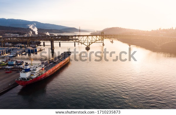 Aerial drone footage of a\
industrial shipyard and cargo ship loading port in Vancouver, BC,\
Canada