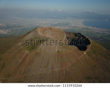 Aerial drone footage of Mount Vesuvius in South Italy on a sunny day.  Its enormity is apparent against the backdrop of Napoli.