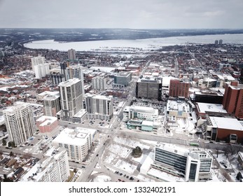 Aerial Drone Image Of Downtown Hamilton, Ontario, Canada During Winter With Apartment Buildings And Low Rise Housing Covered In Snow.