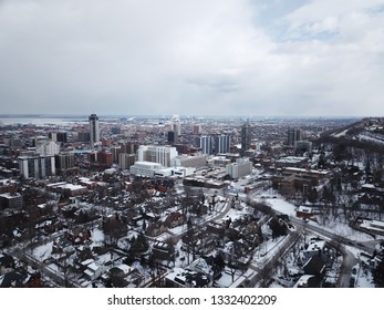 Aerial Drone Image Of Downtown Hamilton, Ontario, Canada During Winter With Apartment Buildings And Low Rise Housing Covered In Snow.