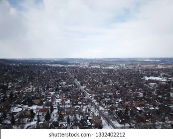 Aerial Drone Image Of Downtown Hamilton, Ontario, Canada During Winter With Apartment Buildings And Low Rise Housing Covered In Snow.