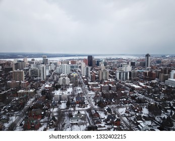 Aerial Drone Image Of Downtown Hamilton, Ontario, Canada During Winter With Apartment Buildings And Low Rise Housing Covered In Snow.