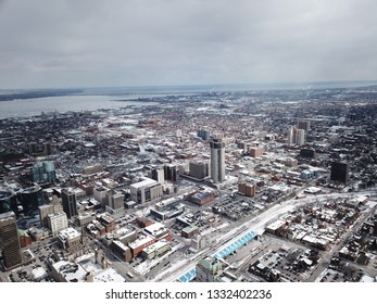 Aerial Drone Image Of Downtown Hamilton, Ontario, Canada During Winter With Apartment Buildings And Low Rise Housing Covered In Snow.