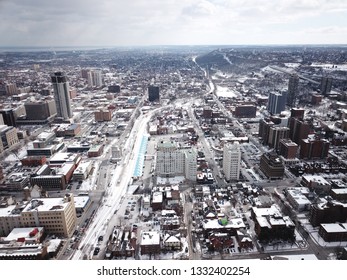 Aerial Drone Image Of Downtown Hamilton, Ontario, Canada During Winter With Apartment Buildings And Low Rise Housing Covered In Snow.