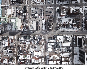 Aerial Drone Image Of Downtown Hamilton, Ontario, Canada During Winter With Apartment Buildings And Low Rise Housing Covered In Snow.