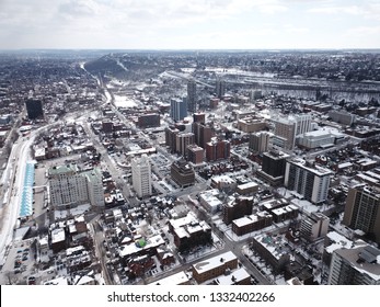 Aerial Drone Image Of Downtown Hamilton, Ontario, Canada During Winter With Apartment Buildings And Low Rise Housing Covered In Snow.