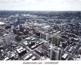 Aerial Drone Image Of Downtown Hamilton, Ontario, Canada During Winter With Apartment Buildings And Low Rise Housing Covered In Snow.