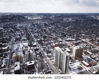 Aerial Drone Image Of Downtown Hamilton, Ontario, Canada During Winter With Apartment Buildings And Low Rise Housing Covered In Snow.