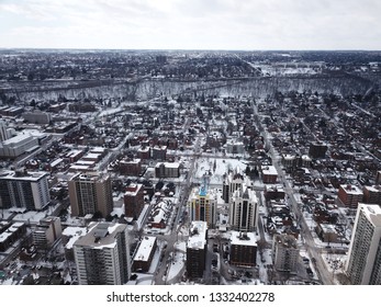 Aerial Drone Image Of Downtown Hamilton, Ontario, Canada During Winter With Apartment Buildings And Low Rise Housing Covered In Snow.