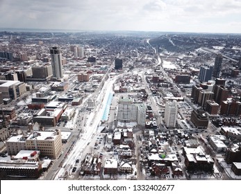 Aerial Drone Image Of Downtown Hamilton, Ontario, Canada During Winter With Apartment Buildings And Low Rise Housing Covered In Snow.