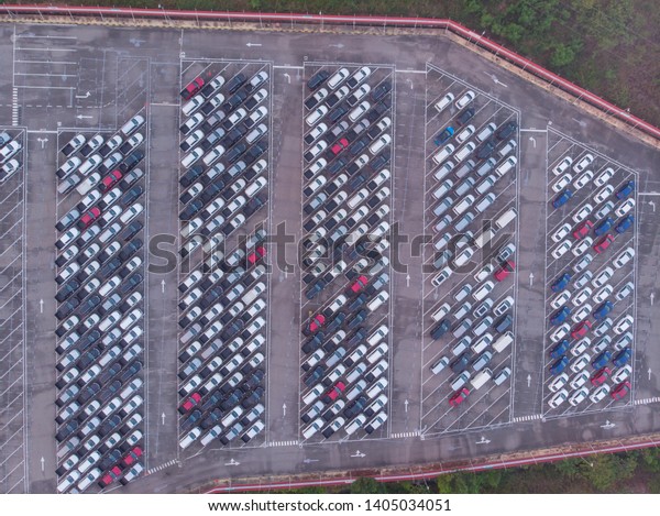 Aerial drone image of a new car parked in\
rows on a lot ready for import export\
business