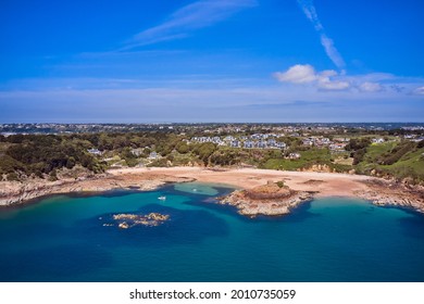 Aerial Drone Image Of Portelet Bay, Jersey, Channel Islands With Blue Sky And Calm Water.