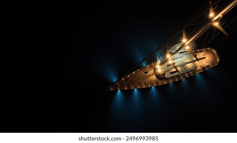 Aerial drone night shot of beautiful illuminated luxury sail boat with wooden deck anchored in deep blue Mediterranean sea - Powered by Shutterstock