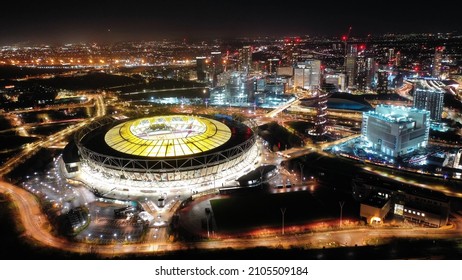 Aerial drone night shot of iconic illuminated London Stadium in Queen Elisabeth park, London, United Kingdom