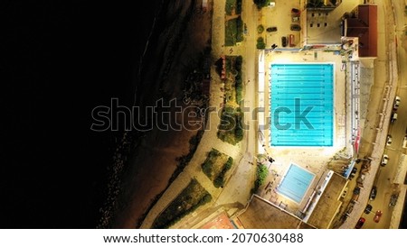 Aerial drone night shot of pool built next to busy port and Marina of Zea or Passalimani, Piraeus, Attica, Greece