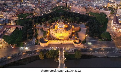 Aerial drone night view of iconic Castel Sant'Angelo (castle of Holy Angel) and Ponte or bridge Sant' Angelo with statues in river of Tiber, Rome, Italy