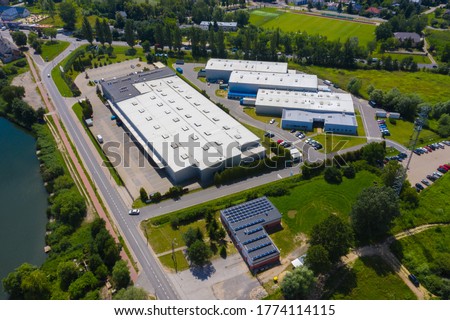 Aerial drone on trucks and logistic center. Warehouse aerial. Modern logistics center, white van and trailers standingon ramp. 