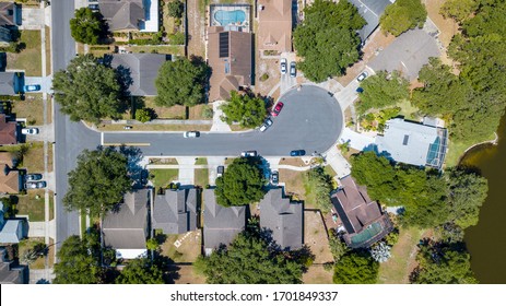 Aerial Drone Overhead View Of A Middle Class Neighborhood Dead End Street In Central Florida On A Lake With Pools And Intersecting Street With Cars On The Street.