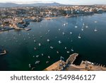 Aerial drone panning over crowded cityscape and Cascais marina in Portugal. From above view of residential area on coast of harbor during sunny day